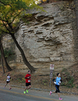 Photo of runners at the Cliff Hanger 8K running by cliffs on Cliff Drive.